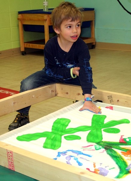 Peter Yaremko participates in the painting of a banner to be put up downtown. The St. Paul &#038; District Boys and Girls Club is one of many community groups taking part in