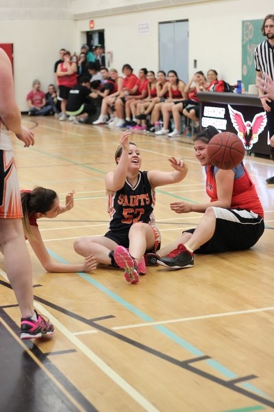 Kendra Desmeules (No. 52) has a laugh as she tosses the ball to a teammate from the floor during the Ashmont Falcons and Saint Paul Saints alumni rivalry game on Friday in