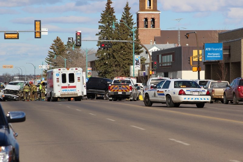 Emergency response teams work to free an RCMP member trapped inside her vehicle following a multiple vehicle collision and shootout on Main Street at around 6 p.m. on Friday