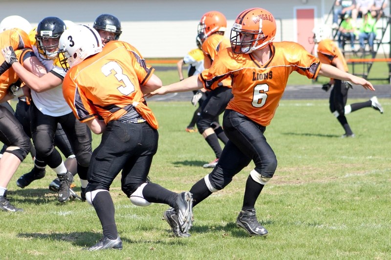 (Clockwise, from top) St. Paul Lions quarterback Patrick Dion hands the ball off to runningback Liam Krys during a game against the Cold Lake Royals at the Lions Jamboree on