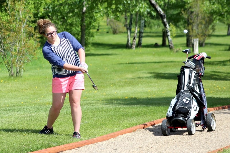 Nevin Jarvis makes an approach shot over the cart path on Hole 9, successfully landing on the green at Saturday&#8217;s Junior Open in St. Paul. Jarvis went on to win the