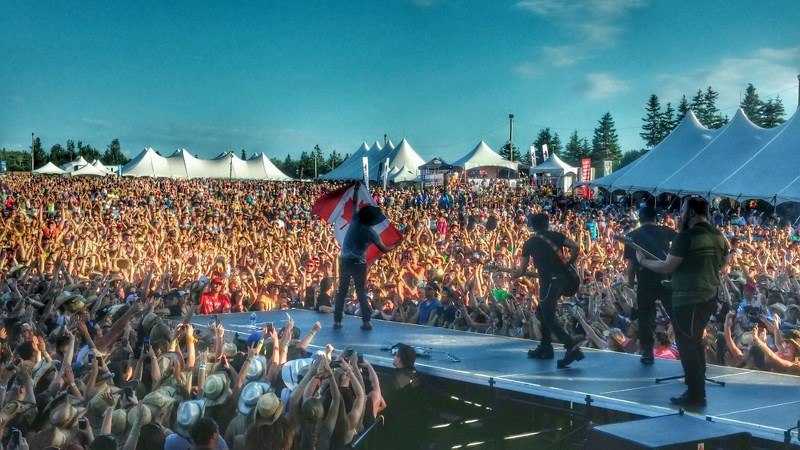 Brett Kissel waves a Canadian flag at Cavendish Fest in Prince Edward Island in early July.
