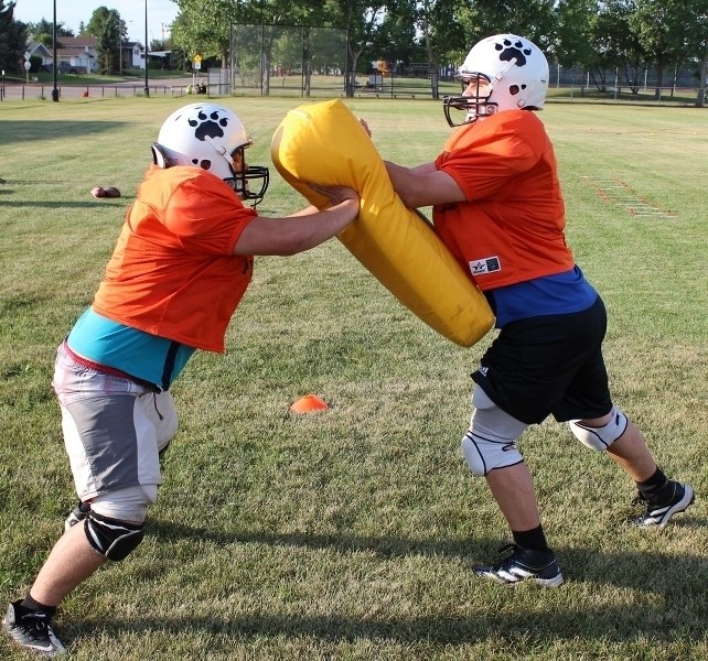 Rueben Johnson (right) holds the bag for Trenton Howse during a linemen drill at camp.