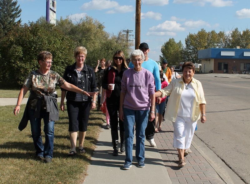 Elk Point Grandparents Day Walk&#8217;s top fundraiser, Peggy Maas, along with several generations of her family, walk down Elk Point on a beautiful Sunday afternoon,