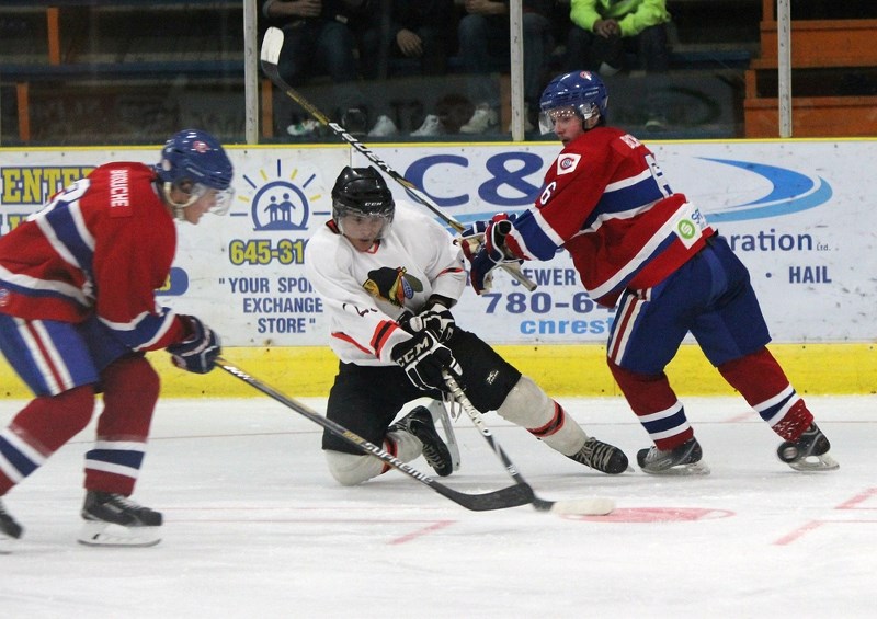 Saddle Lake&#8217;s Rance Cardinal protects the puck from defenders Jalel Abougouche (#8) and Tristan Buchta (#6).