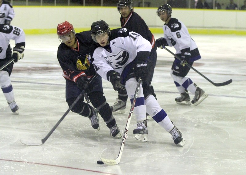Warriors defender Regan Arcand tries to wrestle the puck away from Cold Lake&#8217;s Mike Harbich.