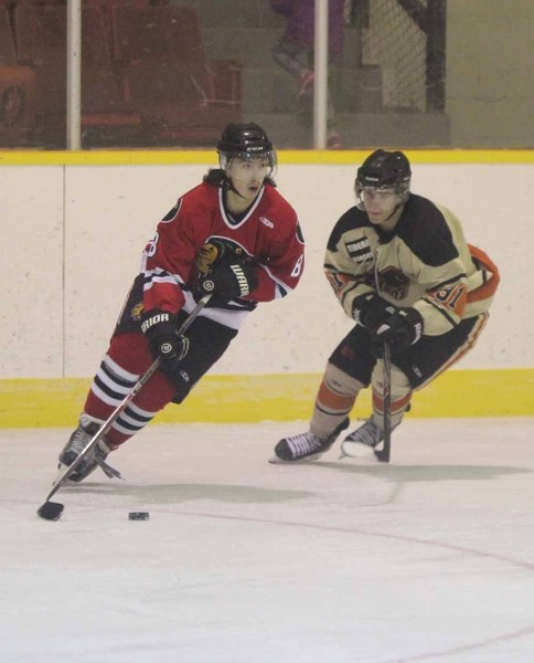 Kevin Jackson Quinney works to protect the puck from a Wainwright defender.