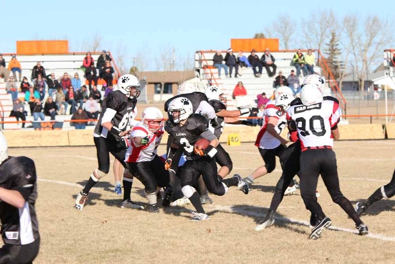 Lions running back Liam Krys hits the hole for an inside run during playoff football action against Vermilion on Nov. 1.