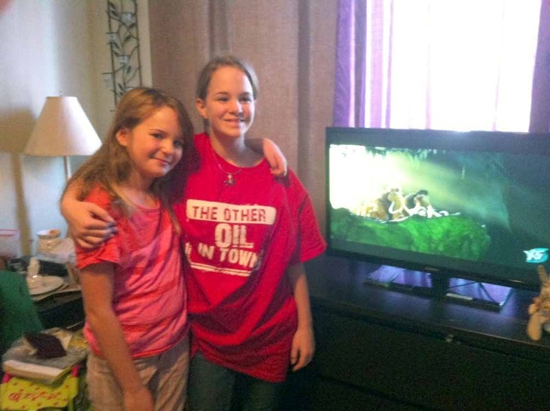 Brianna and Kelli deMoissac stand next to a new TV, offered to the family by a local business owner after the deMoissac family experienced a break-in to their home in late