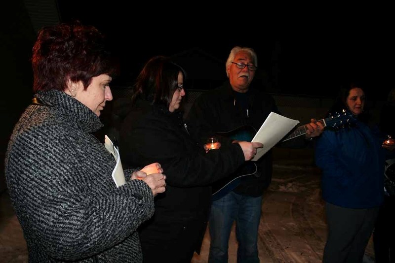 Dawn Lavallee and Tina Debuscherre listen as Hinano Rosa sings during a Nov. 24 candlelight vigil, held to shine a light on the issue of domestic violence.