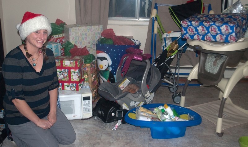 Korrol Eddingfield sits next to a large collection of items she helped collect for a family in need, this Christmas season.