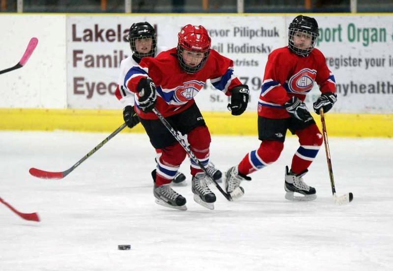 The Canadiens&#8217; Ty Lafrance (red helmet) and Nick Billo keep their eyes on the puck during tournament play in St. Paul.