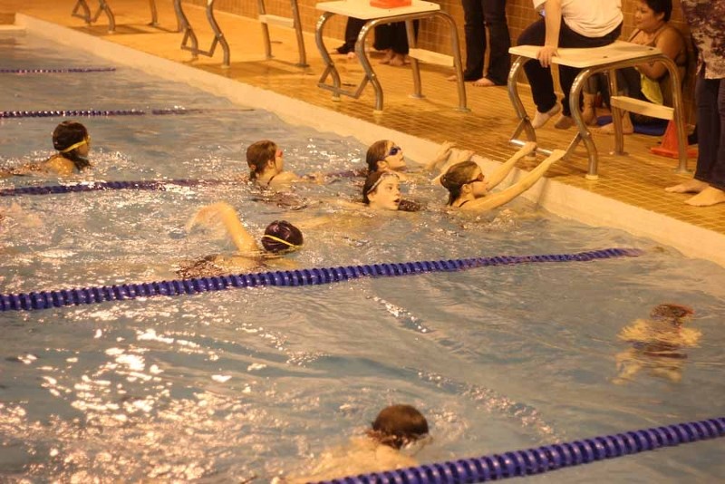 Late in the swim-a-thon, a few swimmers grab a quick breath before setting back out for another lap.