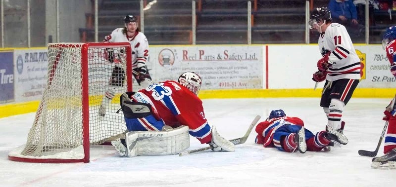 Bryton Beattie (7) takes a dive to protect the net, while goalie Jared Lafond keeps a watchful eye.