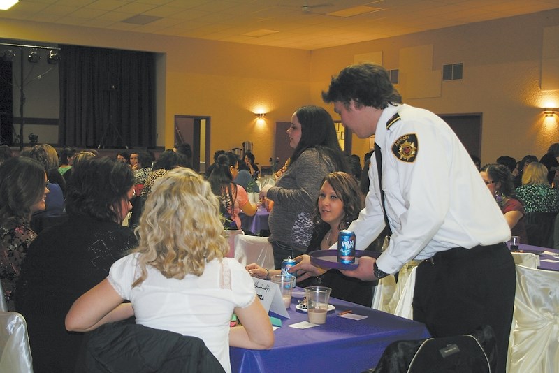 Baxter Bailey serves a table at Ashmont Ladies Night Out on Saturday. Bailey and other crew members of Ashmont fire department were recruited as servers on the night, while
