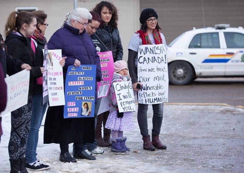 Women stand with signs during the April 2 courthouse rally in St. Paul