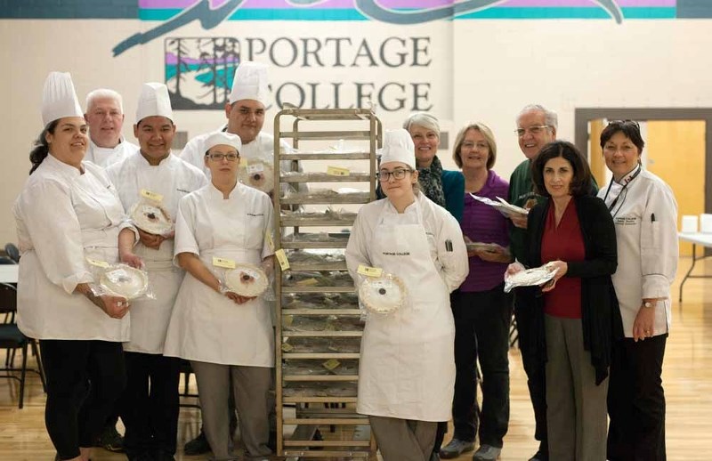Students and staff pose for a photo alongside volunteers with the St. Paul Food Bank on Thursday to hand off a donation of freshly made pies. Pictured is: Ron Mueller, baking 