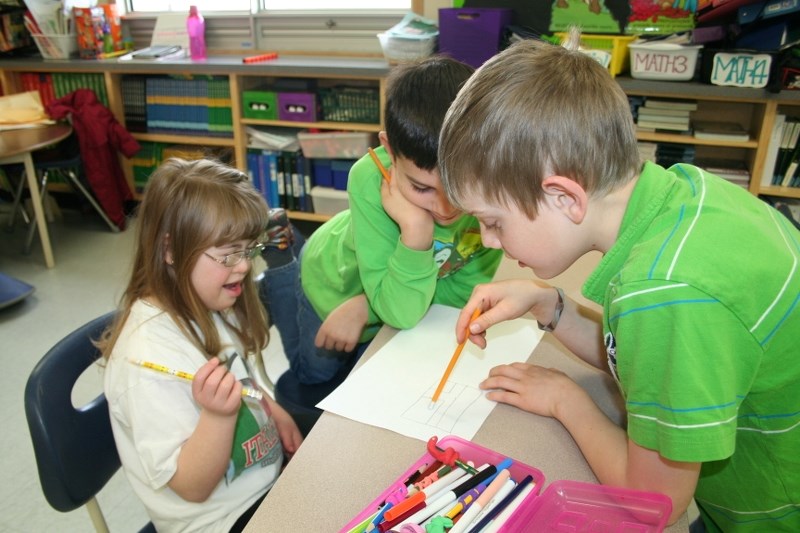 Mallaig School students Ayden Amyotte and Noah Corbiere talk with their classmate Gabrielle Martin about a group project building a house. For the school&#8217;s work in