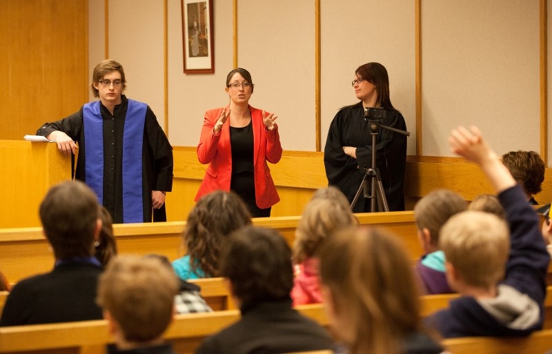 Maryse Culham (pink jacket) answers questions after a group of Students from Ecole du Sommet presented a mock trial in French. Culham, a St. Paul lawyer, helped students
