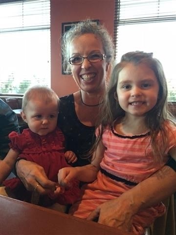 Sue deMoissac is all smiles as she sits with her two granddaughters, Tessa and Brielle.