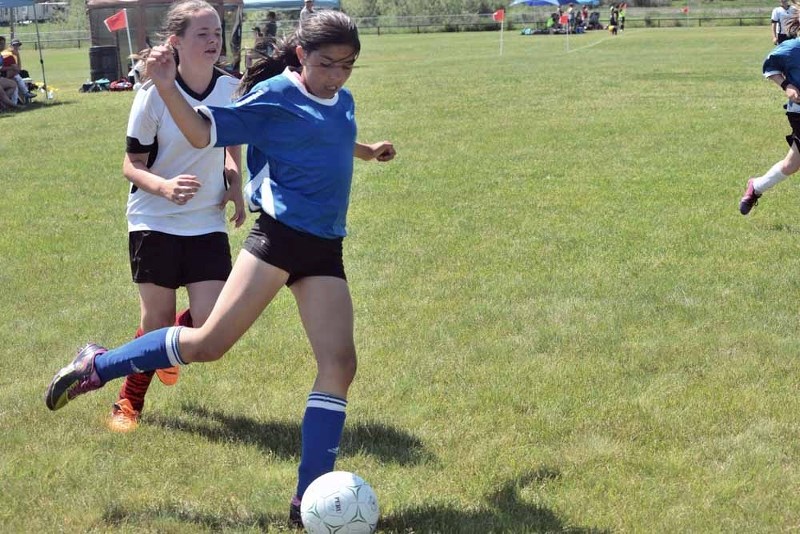 Jessie Kurek (blue) was a standout on Lynzey Brodziak&#8217;s U12 girls team. Here she attempts a sharp angle shot against the Cold Lake net on Sunday.