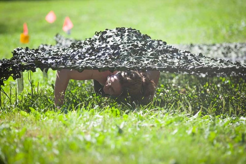 Amanda Pederson crawls under an obstacle near the end of the Bellevue Blast course, Saturday morning.