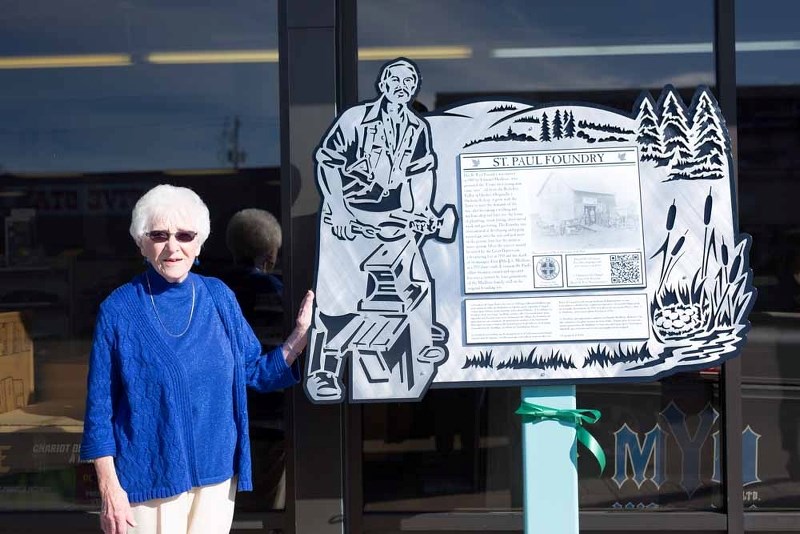 Cecile Bielech stands next to a plaque installed in front of the Foundry.