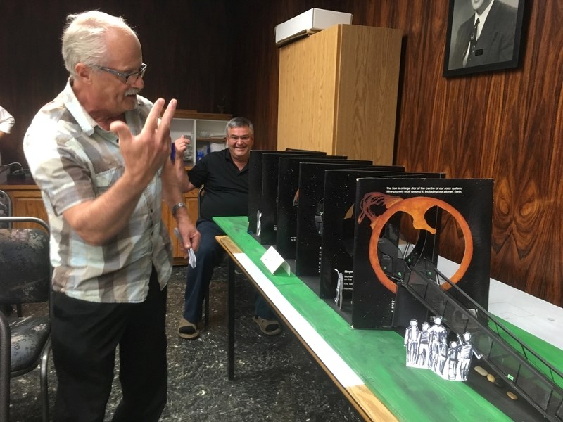 Local artist Herman Poulin unveils his vision for an 85-foot long walk through the solar system that would take visitors through an accordion book of the sun and planets at a 