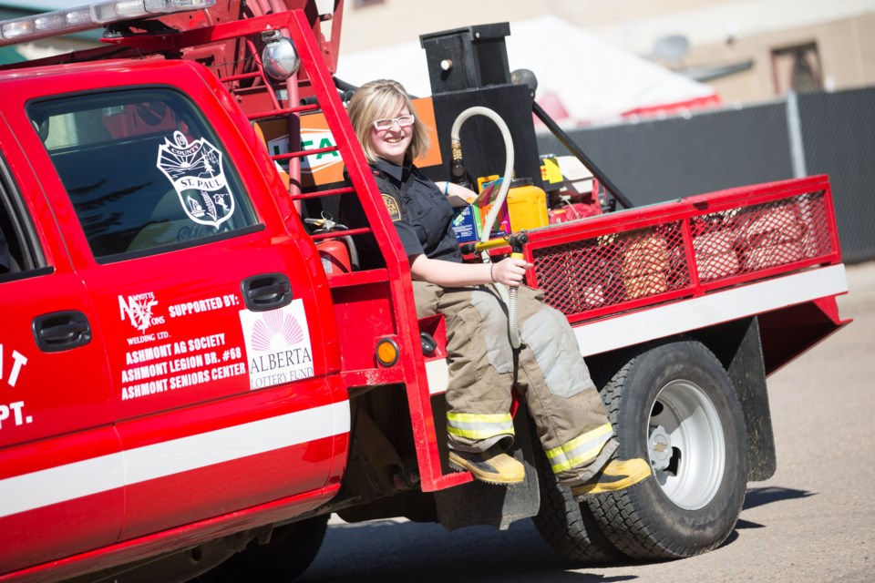 Tiffany Garner of the Ashmont Fire Department helps lead the way during the Ashmont Heritage Days parade last Saturday morning. For more photos and coverage of the event, see 