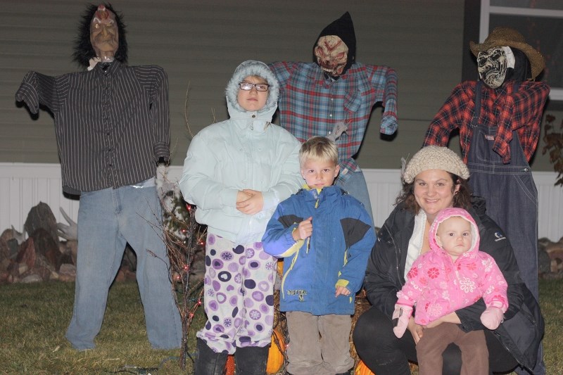 Sheryl Ingram with three of her four children stands outside of her house, with the whole yard decorated in celebration of Halloween. From right to left is Madison, Jaxsyn