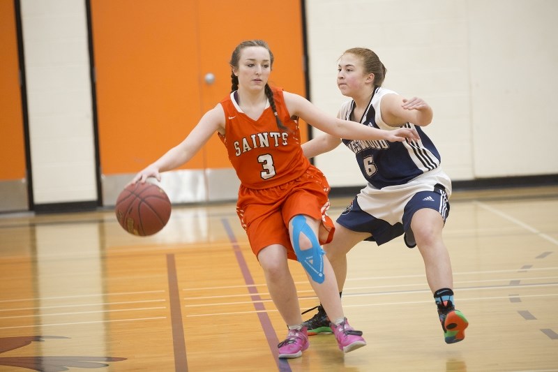 Regional Saints&#8217; Devyn Dubelt protects the ball during the girls&#8217; final game against Westwood at their weekend home invitational basketball tournament.