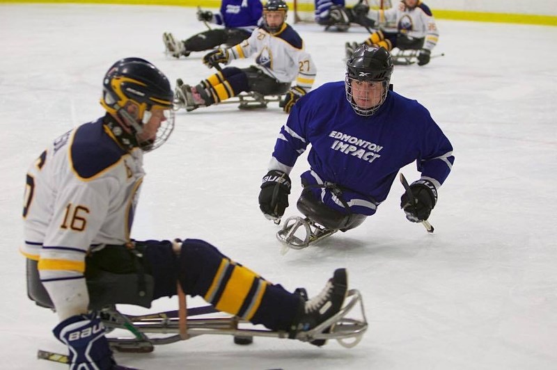 Sledge hockey athlete Eric Dechaine (blue) began playing the sport a few years ago. He now hopes to continue perfecting his skills, and one day he hopes to play for team