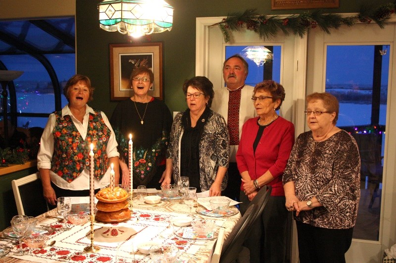 Joanne Ternovoy (left) stands with family and friends to sing a traditional Ukrainian Christmas carol during their Christmas celebrations on the evening of Jan. 6. Also