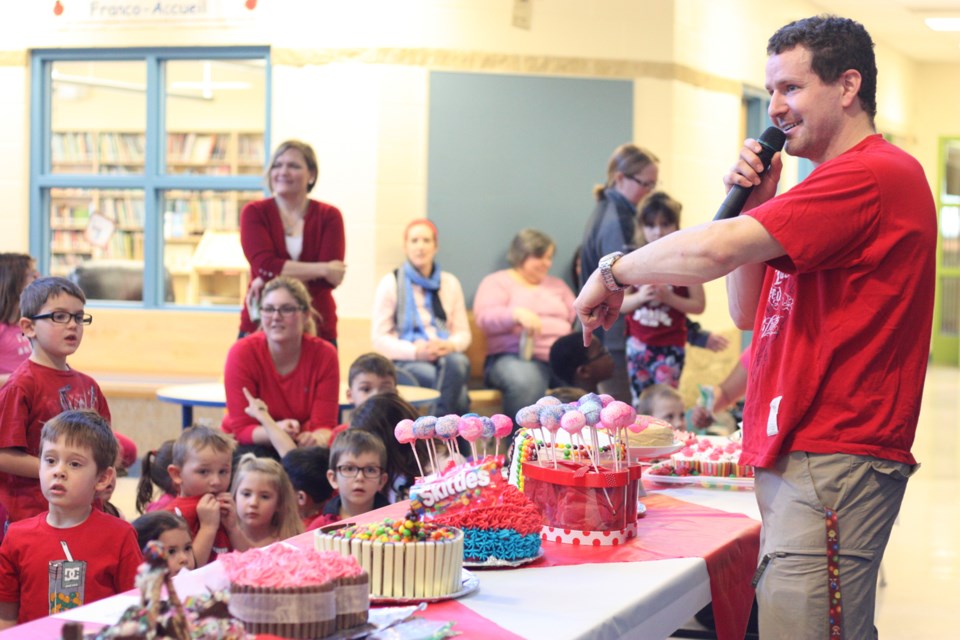 école du Sommet teacher Alain Mah é served as the school&#8217;s auctioneer on Feb. 14, where a sea of students dressed in Valentine&#8217;s Day red got to bid on about 15