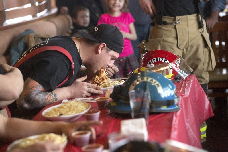Elk Point firefighter Mike Ernst shovels down spaghetti for his team at a contest hosted on March 27 at Boston Pizza, between St. Paul and Elk Point&#8217;s fire departments.