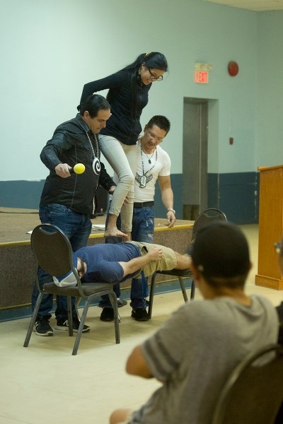 Scott Ward (left) and Dakota House (right) help a participant stand on top of another participant to show how powerful the mind can be.