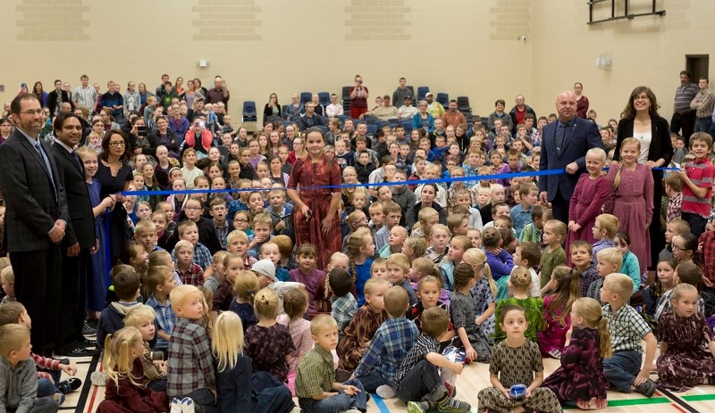 Student Tina Neufeld cuts the ribbon to signify the official opening of the Two Hills Mennonite School, Oct. 5.