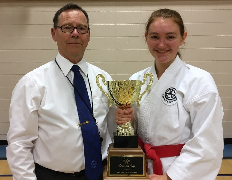 Leah Page is pictured with the 2017 junior female Demura Cup. Presenting the cup is Genbukai Canada Chief Instructor Cameron Steuart.