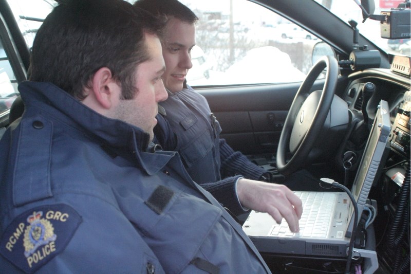 LLB RCMP Constable Chris Clark shows auxillary Darrel Mitchell the workings of the cruiser&#8217;s computer.