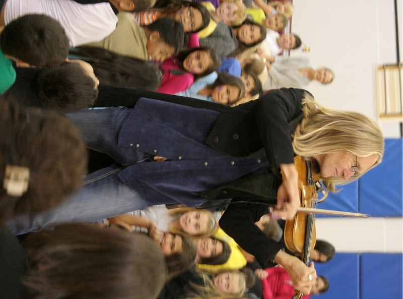 Performer Lowry Olafson runs through the crowd at Central Elementary Wednesday while playing Pachelbel&#8217;s Canon.