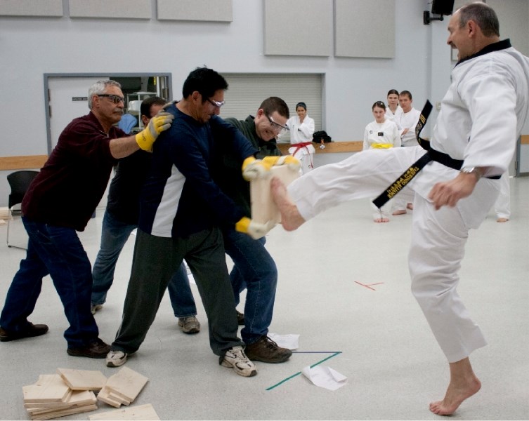 Dale Crossland kicks a wooden board at the Break for Hope fundraiser. Crossland is the instructor for the local taekwondo club.