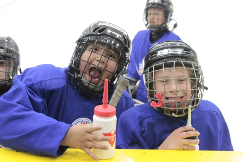 Two lucky players take a water break and pose for the camera during the on-ice portion of the Oilers skills clinic held at the Bold Center.