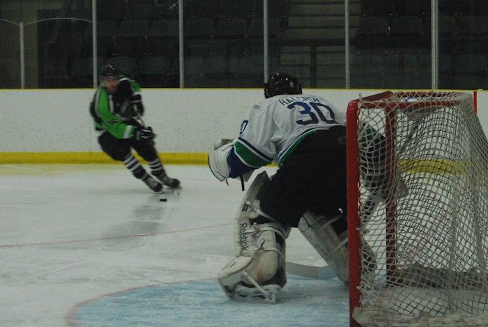 Red Deer College&#8217;s Pat Martens bears down on Voyageurs goalie Kirby Halcrow.