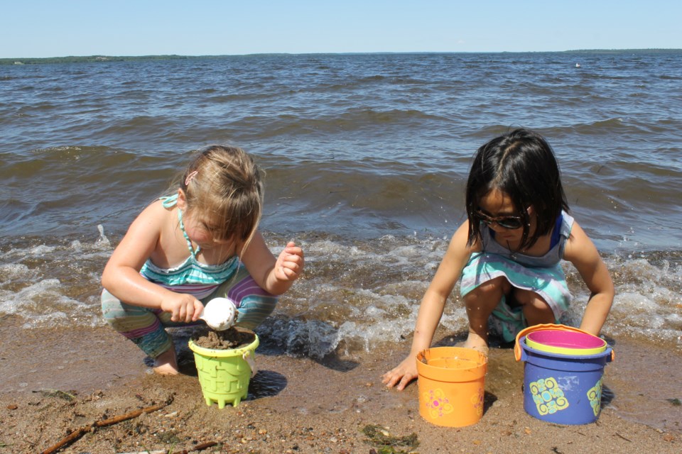 Breeana Son and Ember Edwards playing on the beach at McArthur Park. Field trips and outdoor activities are a main part of the programming for the summer portion of the out