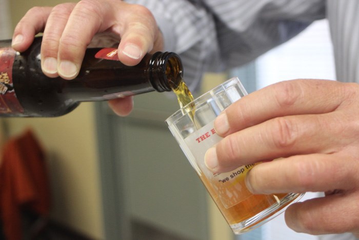 Rotary Club volunteer Ed Behnke executes an expert pour at the club&#8217;s Solstice Beer Experience June 21.