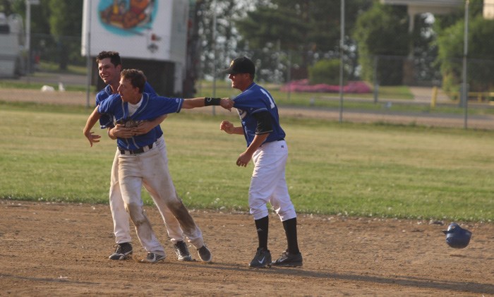 Lac La Biche Dodger Logan Wedgewood is mobbed by teammates after scoring the winning inside-the-park home run in the final of the Pow Wow Days Invitational Baseball