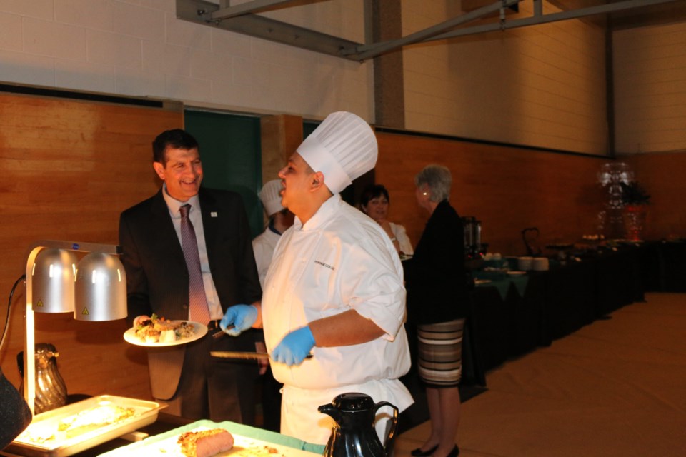 Lac La Biche mayor Omer Moghrabi is served roast beef by Portage College culinary arts student Kyle Girow at the gala.