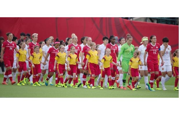 Members of the Lakeland Soccer Club&#8217;s U10 girls team accompany Team Canada onto the pitch at Commonwealth Stadium in Edmonton, ahead of the team&#8217;s opening match