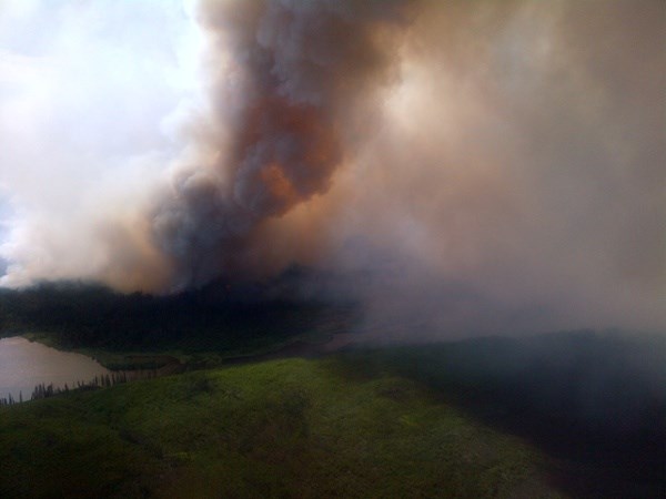 An earlier photograph shows a column of smoke from the Caribou Lake fire.