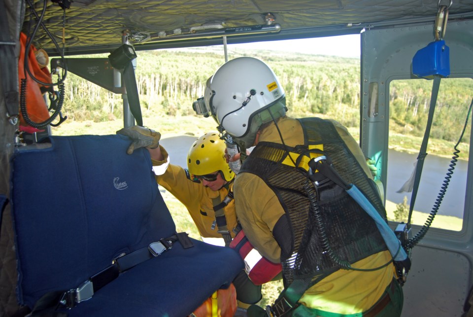 Firefighter Laura Grant gets ready to rappel, with help from rappel spotter Ben Bartlett.